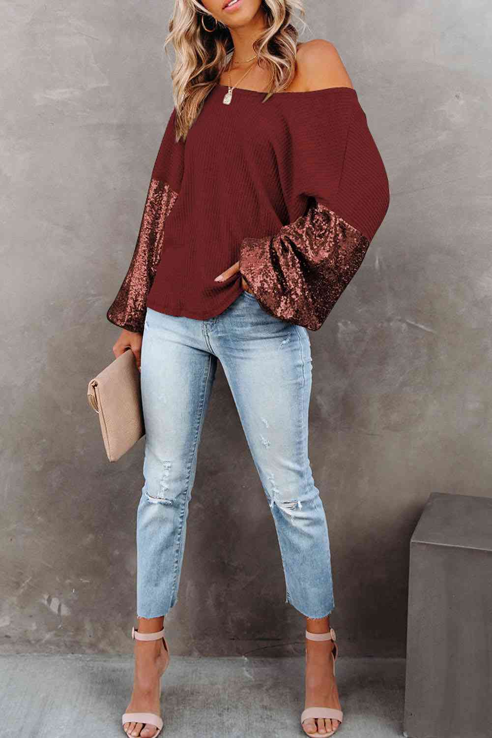 Front view of model wearing sequin sleeve waffle knit blouse in the color wine
